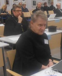 Kirkolliskokousedustaja Anja Lindström. Taustalla Helsingin seurakunnan kirkkoherra isä Markku Salminen.